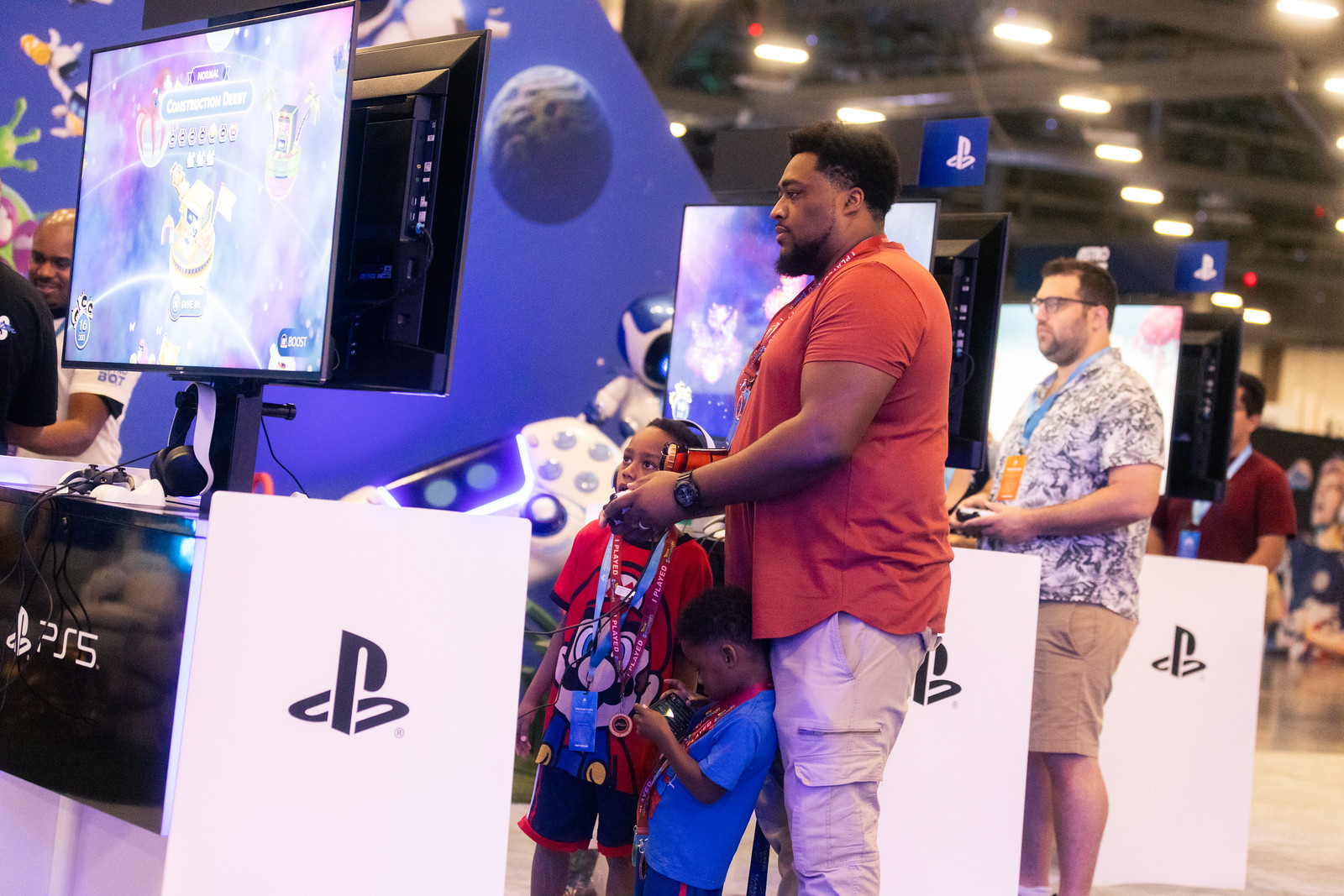 Family plays PS5 at a PlayStation demo booth.