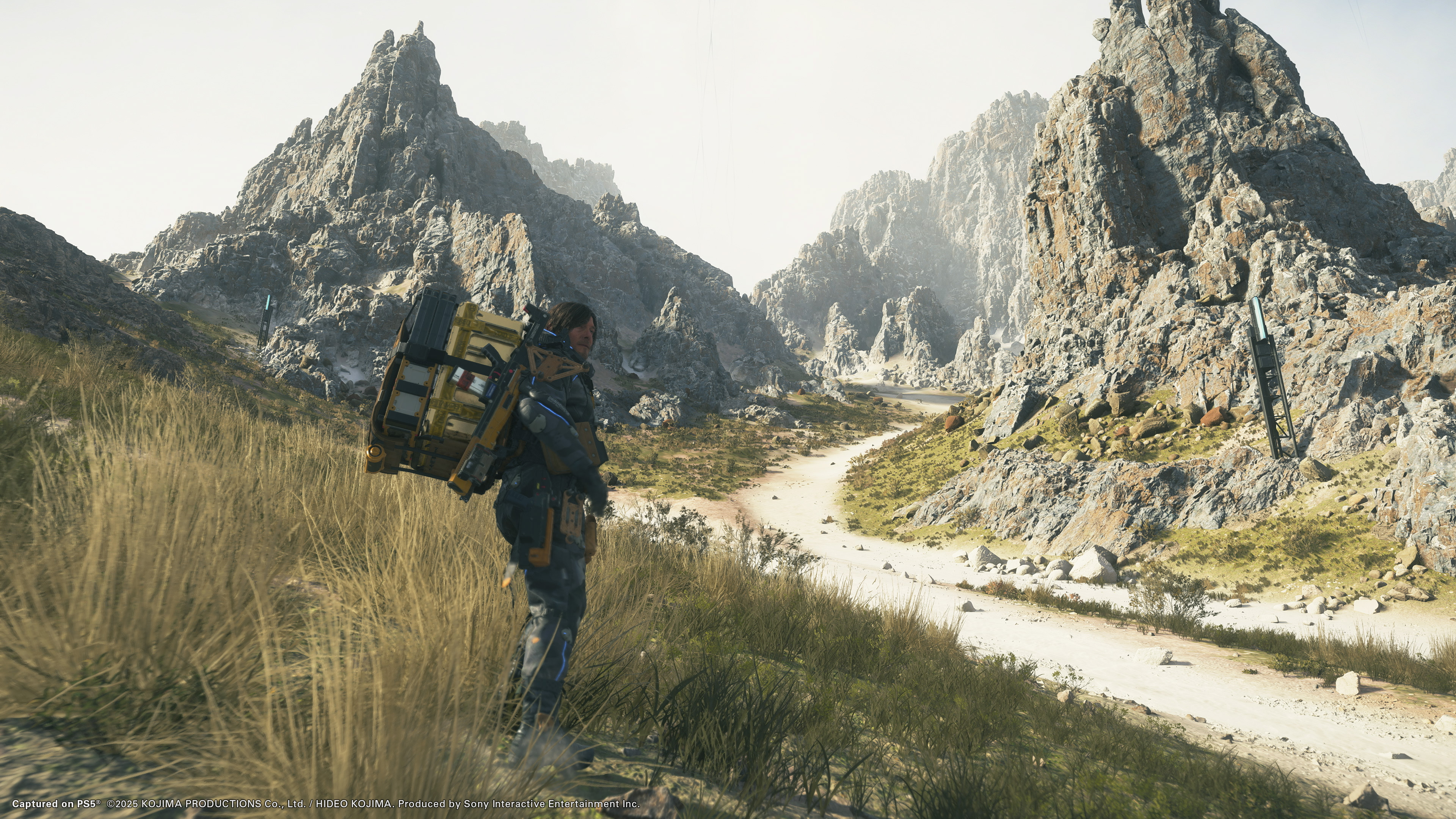 Death Stranding 2: On the Beach screenshot showing Sam in a mountainous environment
